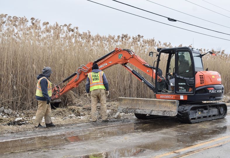 picture of workers on 143rd Street attempting to relieve flooding and ice