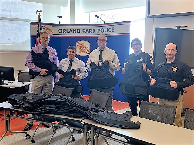 picture of Orland Park Police Officers holding vests donated to the people of Ukraine